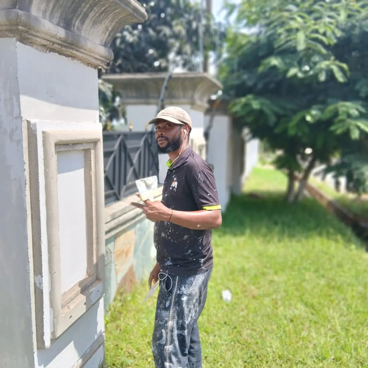 Worker finishing wall beside gate