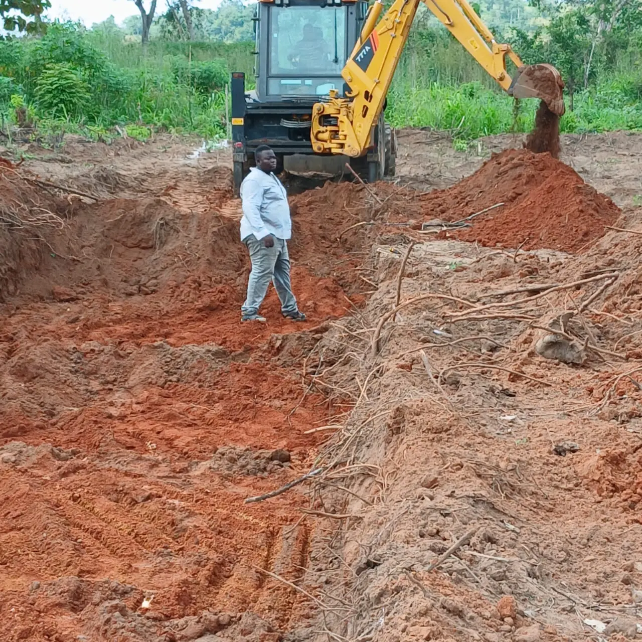 Excavator working on red earth construction site